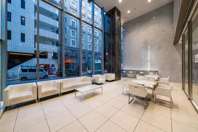 a restaurant with white chairs and tables and windows at KOKO HOTEL Ginza-1chome in Tokyo