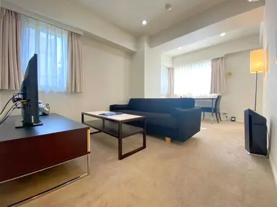 a living room with a blue couch and a tv at Pangoo Shinagawa in Tokyo