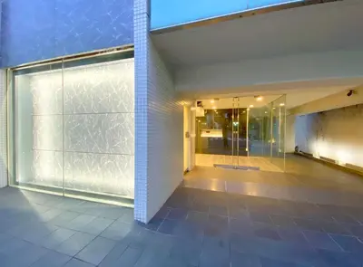 a glass door in a building with a walk in shower at Pangoo Shinagawa in Tokyo