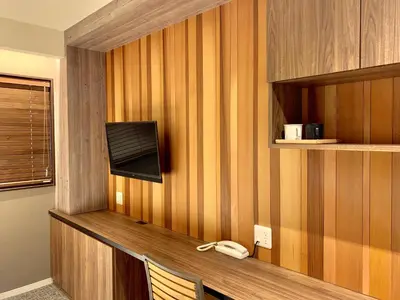 a room with a desk with a phone on a wall at \u6d45\u8349\u96f7\u9580 \u7af9\u4e43\u5bbf in Tokyo