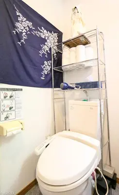 a bathroom with a white toilet and a towel at Fuji House West Shinjuku in Tokyo