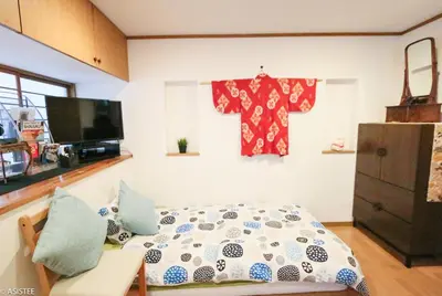 a bedroom with a bed and a shirt hanging on the wall at Fuji House West Shinjuku in Tokyo
