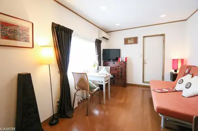 a living room with a table and a chair at Fuji House West Shinjuku in Tokyo