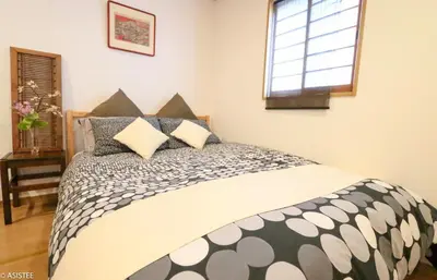 a bedroom with a bed with a black and white comforter at Fuji House West Shinjuku in Tokyo