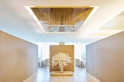 a vase of flowers in a room with a chandelier at The Okura Heritage Tokyo in Tokyo