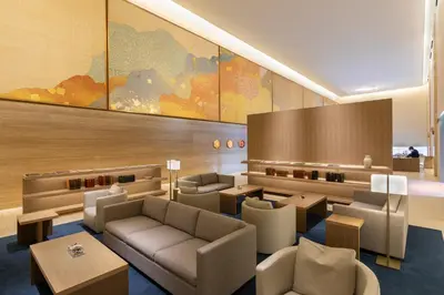 a lobby with couches and tables and a map on the wall at The Okura Heritage Tokyo in Tokyo
