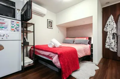 a bedroom with two beds with a red blanket at North Cottage Studio Apartment with private entrance in Tokyo