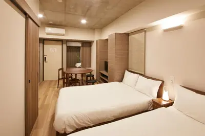 a hotel room with two beds and a table at Prime Suites Tokyo in Tokyo
