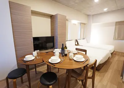 a room with a table and chairs and a bed at Prime Suites Tokyo in Tokyo