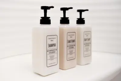three white bottles of laundry detergent sitting on a counter at Prime Suites Tokyo in Tokyo