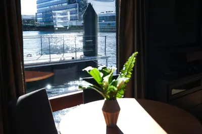 a vase of flowers on a table in front of a window at PETALS TOKYO - Floating Hotel in Tokyo