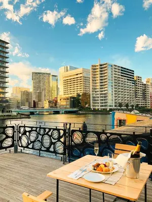 a table with a plate of food on a balcony at PETALS TOKYO - Floating Hotel in Tokyo