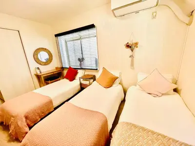 a room with three beds and a window at YUYUSO Hostel-SG0165 in Tokyo