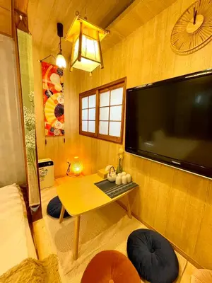 a room with a table and a large flat screen tv at YUYUSO Hostel-SG0165 in Tokyo
