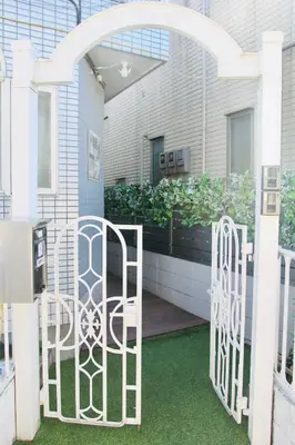 a white gate in front of a building at YUYUSO Hostel-SG0165 in Tokyo
