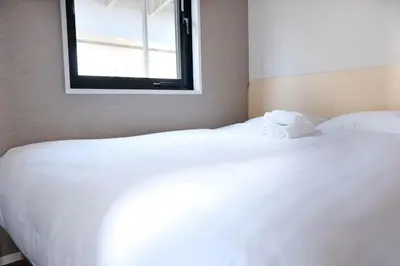 a bedroom with a large white bed with a window at The Light Inn - Vacation STAY 94704 in Tokyo
