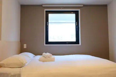 a bedroom with a bed with two towels on it at The Light Inn - Vacation STAY 94704 in Tokyo