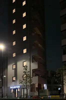 a tall building with a sign in front of it at night at The Light Inn - Vacation STAY 94704 in Tokyo