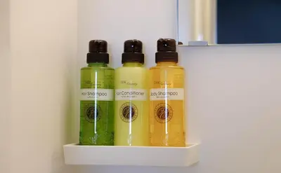 four bottles of liquids sitting on a shelf at The Light Inn - Vacation STAY 94702 in Tokyo