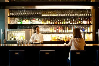 a man and a woman standing at a bar at The Gate Hotel Kaminarimon by Hulic in Tokyo
