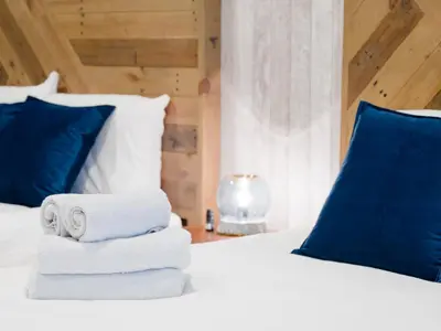 a white bed with blue pillows and towels on it at Sukumo -\u8485- in Tokyo
