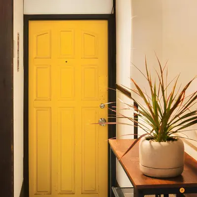 a yellow door with a potted plant on a table at Close to Shinjuku! 3BR House for 10, Kids Welcome, High-Speed Wi-Fi in Tokyo