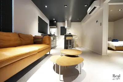 a living room with a couch and two tables at Real Life AOYAMA in Tokyo