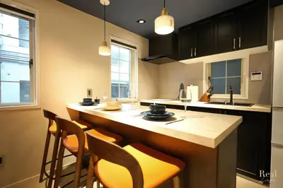 a kitchen with a counter and some chairs in it at Real Life AOYAMA in Tokyo