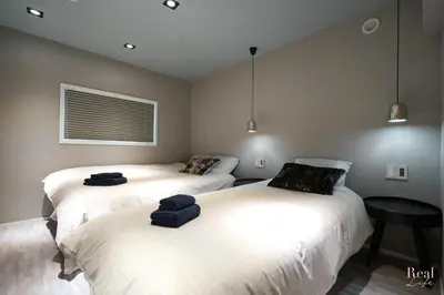 a bedroom with two beds with towels on them at Real Life AOYAMA in Tokyo
