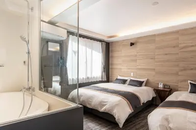 a bedroom with a tub and a bed and a shower at NEXUS HOTEL Ebisu in Tokyo