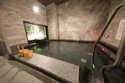 a swimming pool in a room with a stone wall at Super Hotel Tokyo Akabane Eki Minamiguchi in Tokyo