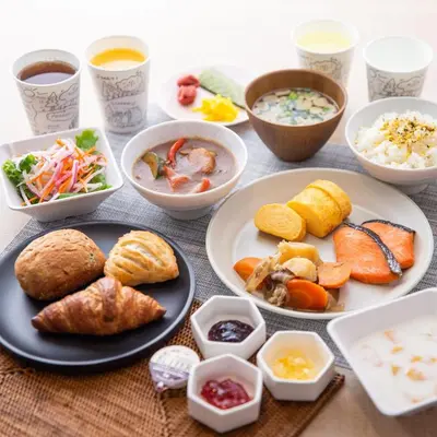 a table with plates of food and bowls of food at Super Hotel Tokyo Akabane Eki Minamiguchi in Tokyo