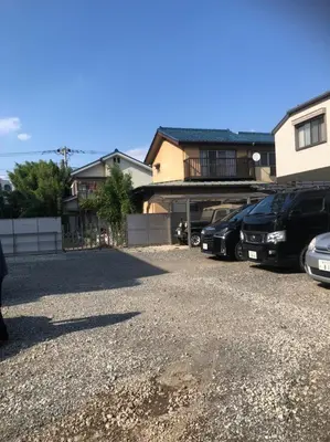 a parking lot with cars parked in front of a house at Holy House in Tokyo