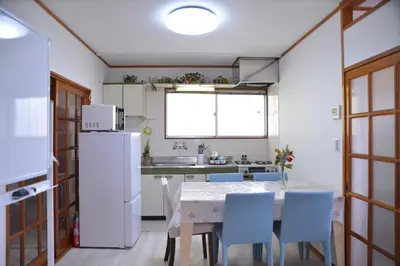 a kitchen with a table and chairs and a refrigerator at Green House 201 in Tokyo