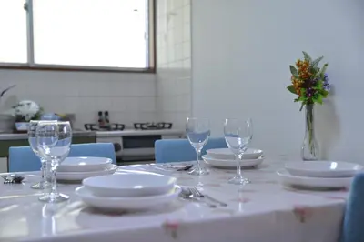 a table with glasses and plates and a vase of flowers at Green House 201 in Tokyo