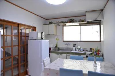 a kitchen with a table and a white refrigerator at Green House 201 in Tokyo