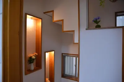 a hallway with stairs and a vase of flowers at Green House 201 in Tokyo