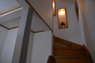 a stairway with a flower in a picture on the wall at Green House 201 in Tokyo