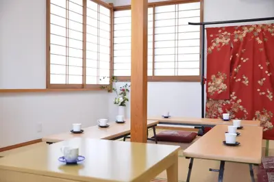 a room with tables and windows with flowers on the wall at Green House 201 in Tokyo