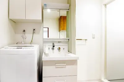a small white kitchen with a sink and a mirror at TOGOSHI 568 STAY Togoshi Ginza in Tokyo