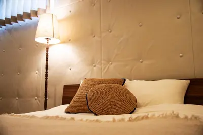 a bed with a brown pillow and a lamp at TOGOSHI 568 STAY Togoshi Ginza in Tokyo