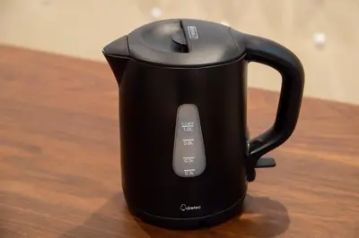 a black tea kettle sitting on a wooden table at TOGOSHI 568 STAY Togoshi Ginza in Tokyo