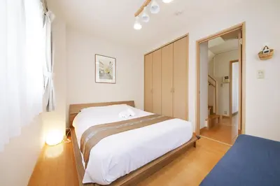 a bedroom with a large white bed and a mirror at \u62bc\u4e0a\u30cf\u30a6\u30b9 in Tokyo