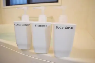 three white bottles of soap sitting on a bathroom sink at \u62bc\u4e0a\u30cf\u30a6\u30b9 in Tokyo