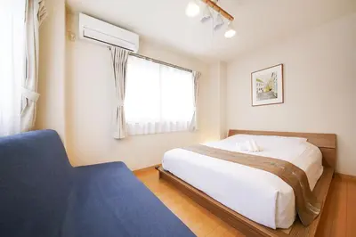 a bedroom with a large bed and a window at \u62bc\u4e0a\u30cf\u30a6\u30b9 in Tokyo