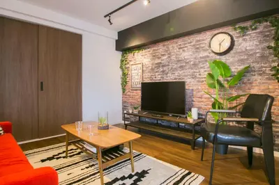 a living room with a brick wall and a tv at Shibuya Park Residence Yoyogi Park in Tokyo