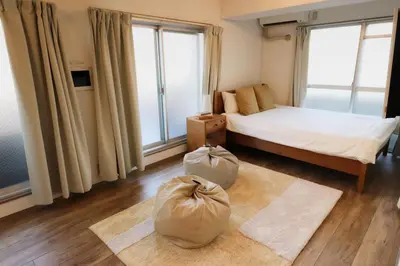 a bedroom with a bed and two bags on the floor at Shibuya Park Residence Yoyogi Park in Tokyo