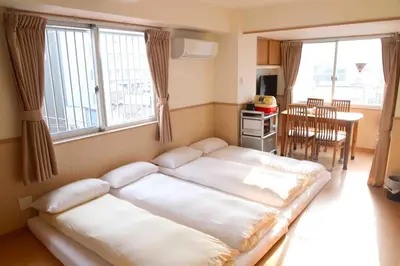a room with two beds in a room with a table at \u4e0a\u91ce\u4e4b\u5bb6\u5206\u9928\u5bb6\u5ead\u623f in Tokyo