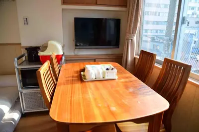 a dining room table with chairs and a television at \u4e0a\u91ce\u4e4b\u5bb6\u5206\u9928\u5bb6\u5ead\u623f in Tokyo
