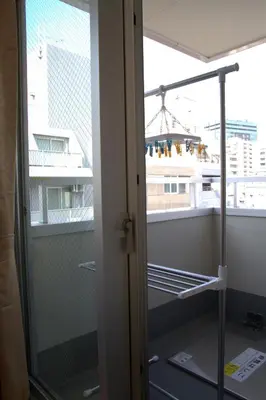 a glass door to a balcony with a view of a building at \u4e0a\u91ce\u4e4b\u5bb6\u5206\u9928\u5bb6\u5ead\u623f in Tokyo